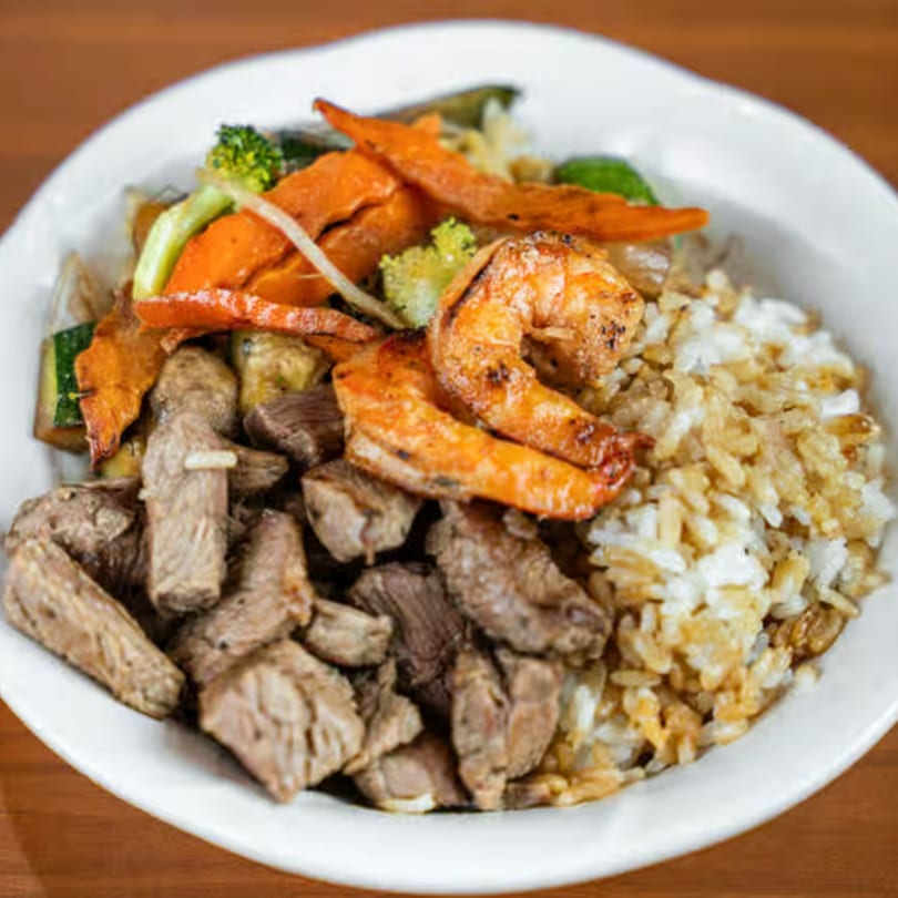 Kyoto Japanese Steak House hibachi meal with steak, shrimp, vegetables, and fried rice in a white bowl.