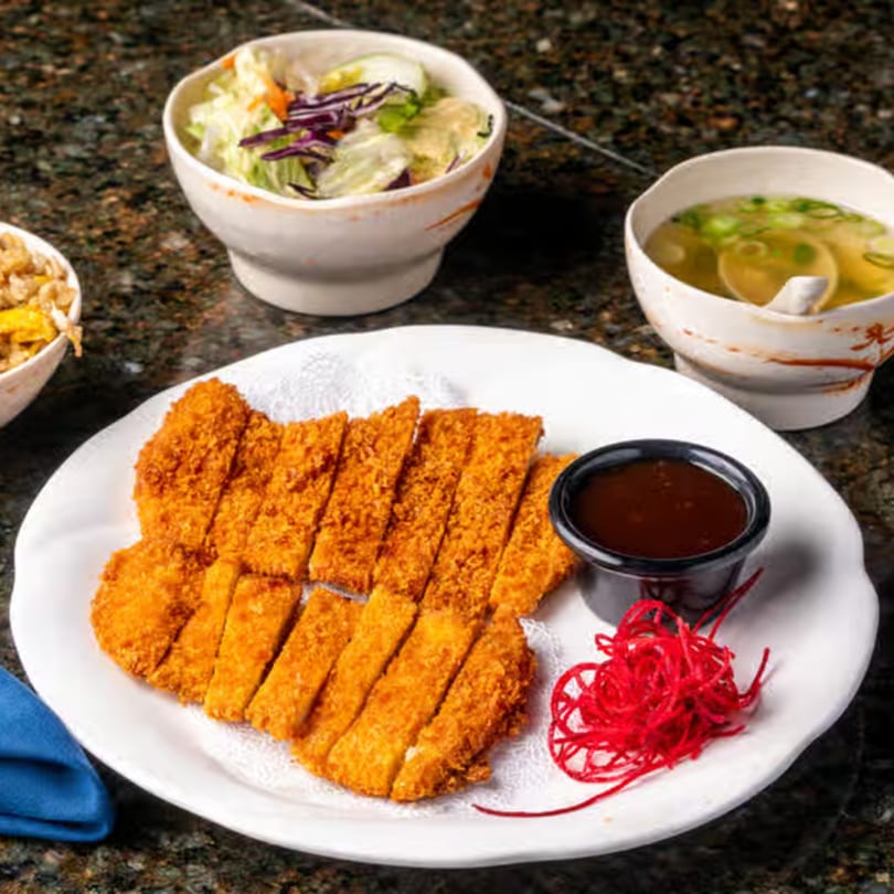 Crispy Japanese tonkatsu, sliced and served with dipping sauce, salad, and soup.
